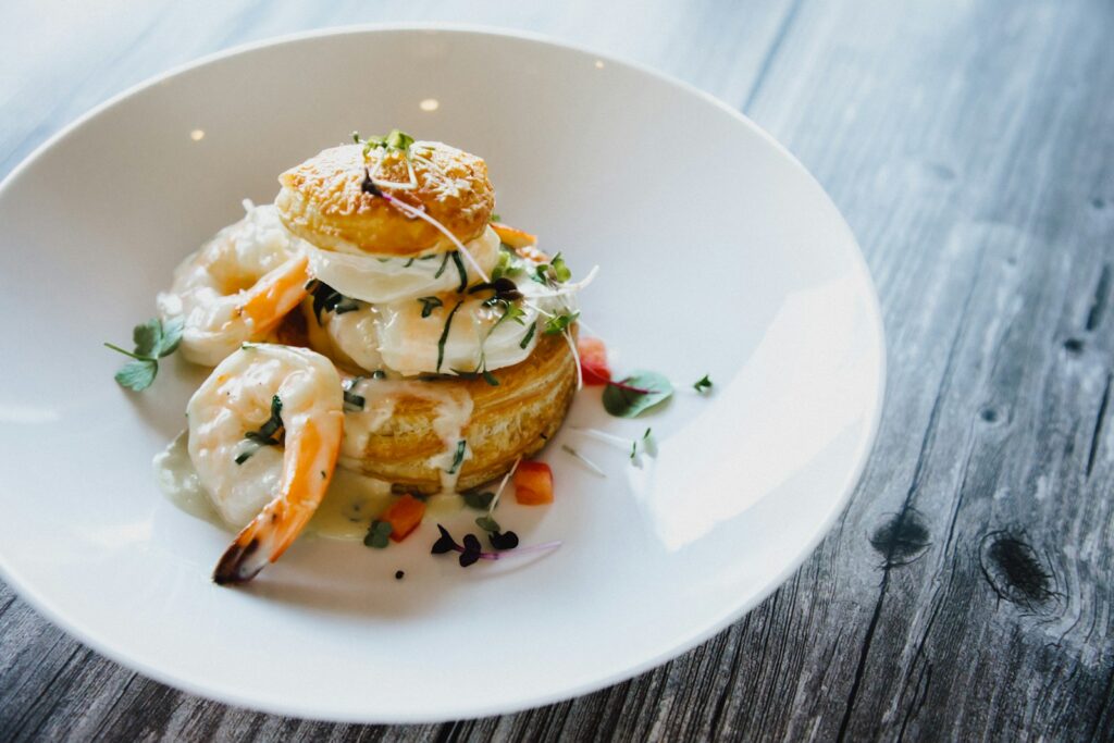 Photo by Anima Visual a white plate topped with food on top of a wooden table